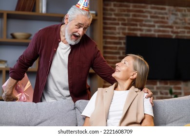 Caring Old Husband Giving Romantic Birthday Present To Excited Mature Wife, Loving Older Man Surprise Happy Middle Aged Woman, Open Pink Box, Kiss, Hug Husband, Celebrating Together.