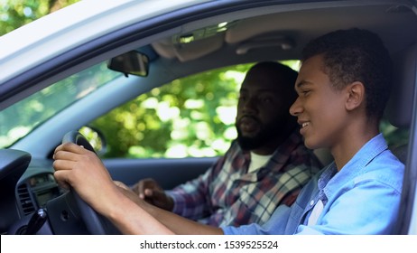 Caring Parent Teaching Son How To Drive Car, Spending Time Together, Family