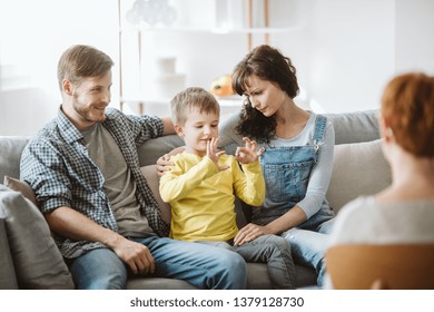 Caring parents and misbehaving boy during therapy session with counselor