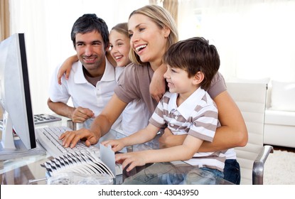 Caring parents teaching their children how to use a computer in the living-room - Powered by Shutterstock