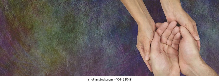 Caring for those in need - rustic dark stone effect wide background with a woman's hands cupped around a man's hands depicting a carer 