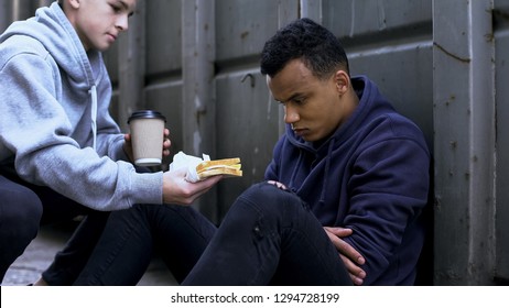 Caring volunteer boy brings dinner to homeless teenager, kind heart, charity - Shutterstock ID 1294728199