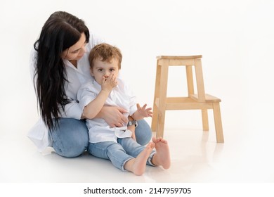 Caring woman and boy hugging, spending time together. Close bounding between mother and son, quieting, sitting on floor