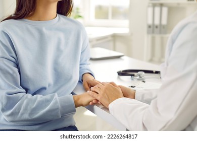 Caring woman doctor holding female patient hand giving recommendations for treatment and hope for recovery from dangerous disease and consultations on use of drugs sits at desk in clinic office - Shutterstock ID 2226264817