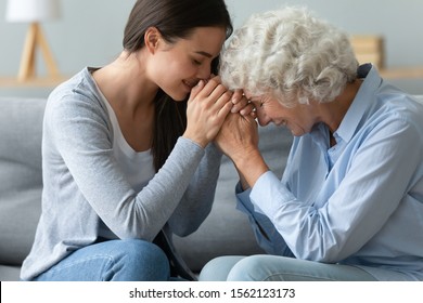 Caring Young Adult Woman Granddaughter Hold Hands Of Old Mature Grandmother Bonding Feeling Gratitude Sit On Sofa, Happy Two Age Generation Women Love, Grandparent And Grandchild Support Concept