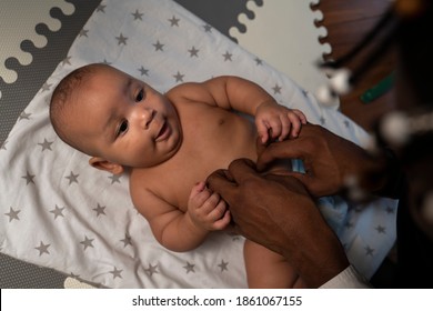 Caring Young Black Father Changing Baby Diaper . Fatherhood And Multiracial Family. High Quality Photo