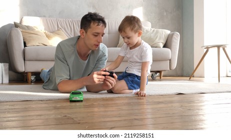 Caring young father plays with his preschool son, drives a radio-controlled toy car, loves to spend time together. Young family having fun playing - Powered by Shutterstock