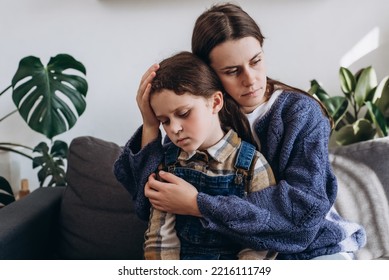 Caring Young Mother Hugging, Calming Upset Little Daughter, Sit On Couch In Living Room At Home, Loving Mommy Comforting Offended Sad Girl Child, Expressing Love And Support. Kid Psychologist Concept