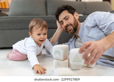 Caring young single father playing with cute kid daughter with soft blocks. - Shutterstock ID 2299927809