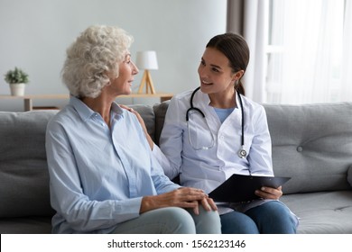 Caring Young Woman Nurse Help Old Granny During Homecare Medical Visit, Female Caretaker Doctor Talk With Elder Lady Give Empathy Support Encourage Patient Sit On Sofa Older People Healthcare Concept