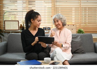 Caring Young Woman Showing Useful Applications, Teaching Retired Mother Using Digital Tablet. Elderly, Technology Concept