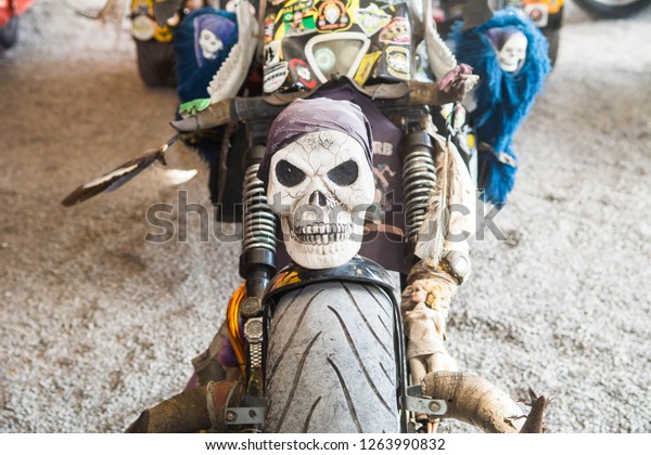 Carlos Barbosa/Rio Grande do\
Sul/Brazil - September 16, 2018: Skull detail of a bike during\
motorcycle meeting. Several bikes and people can be seen in the\
background.