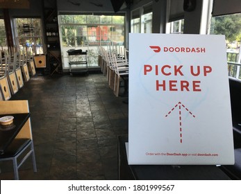 Carlsbad, CA / USA - August 12, 2020: A Sign In A Restaurant Closed To Indoor Dining Points Dashers Where To Pick Up Take Out Orders.