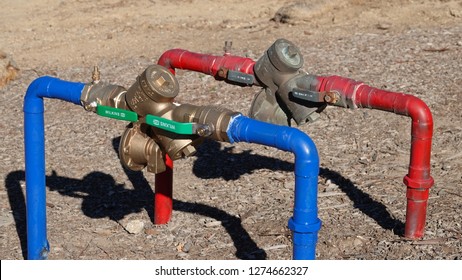 Carlsbad, CA / USA - January 4, 2019: valves with backflow preventer on red and blue water lines                              