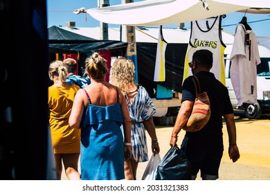 Carmona, Spain August 9, 2021 A Group Of Adult People Back Turned Walking And Wearing Masks In Mandatory In A Local Market Set Up Every Monday During The Coronavirus Outbreak