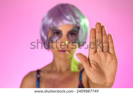 Carnaval Brazil. Hands and gesture: Stop, no harassment. Face of brazilian woman with violet wig and make up mask. Color background. Masquerade concept, celebration and festival.