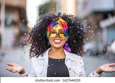 Carnaval party. Brazilian curly hair woman in costume blowing confetti - Powered by Shutterstock