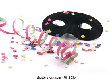 carnival concepts paper confetti streamers and black mask isolated on white background
