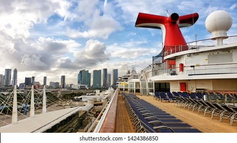 Carnival Cruise Ship Funnel In Traditional Red, White And Blue Compony Colors. Open Deck Of The Cruise Ship.  Chaise Lounges On A Deck In The Morning. Nobody On A Deck. Miami, May 23, 2019