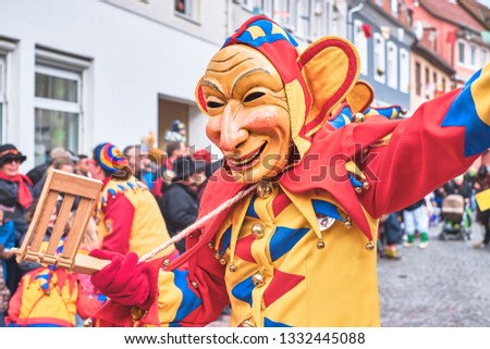 Carnival figure with big ears and long face in yellow red blue robe. At the carnival in south germany.