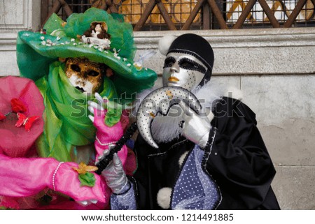 Carnival pair multicolor mask and costume at the traditional festival in Venice, Italy
