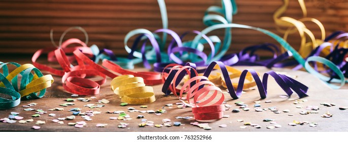 Carnival Party Concept. Colorful Confetti And Serpentines On Wooden Floor Background