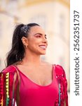 Carnival street portrait of smiling woman in costume. Latin girl in bright makeup and summer costume.