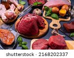 Carnivore diet background. Various non-vegan protein sources, Traditional Carnivore food - meat and fish, chicken breast, pork steak, beef steak, patty, heart, liver, eggs with spices for cooking