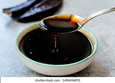 Carob Molasses Dripping From Spoon