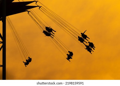 Carousel In The Amusement Park.Silhouettes Of People