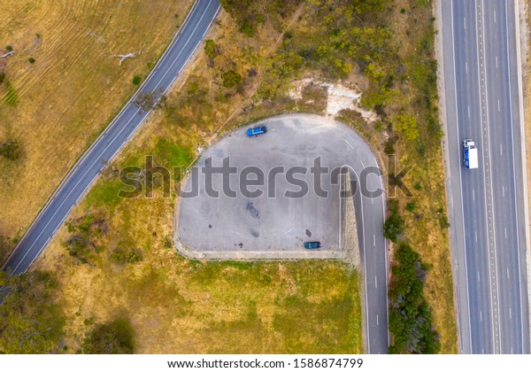 A carpark and road system\
running through large green farmland south of Adelaide in\
Australia