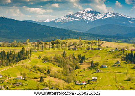 Carpathian village on a spring rolling hills in a mountain valley.
