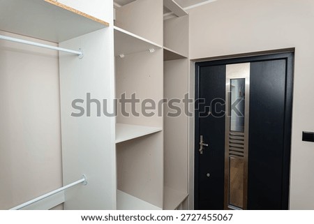 A carpenter assembling a wardrobe in a vestibule, a precise handiwork.