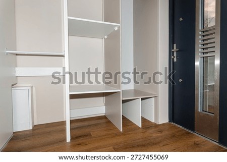 A carpenter assembling a wardrobe in a vestibule, a precise handiwork.