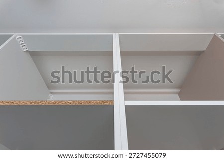 A carpenter assembling a wardrobe in a vestibule, a precise handiwork.