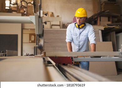 Carpenter In A Bright Furniture Factory Operating On Wood Processing Machine