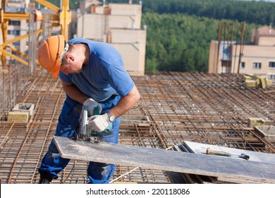 Carpenter Builder Man Worker Cutting Wood Sheet With Handheld Circular Saw Machine During Construction Formwork Works