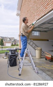 Carpenter Caulking Cracks Between Garage Door Frame And Brick