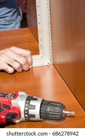 The Carpenter Checks The Right Angle With Builder's Square 