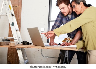 Carpenter and client using laptop