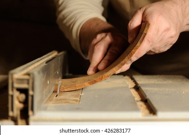 Carpenter Cutting Curved Piece Of Wood By Wood Cutter