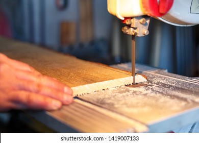 Carpenter Cutting a Piece Of Wood With Bandsaw In Workshop - Powered by Shutterstock