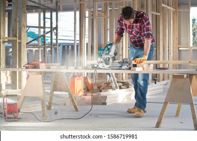 Carpenter Cutting Wood With Circular Power Saw In Building Construction Site Interior