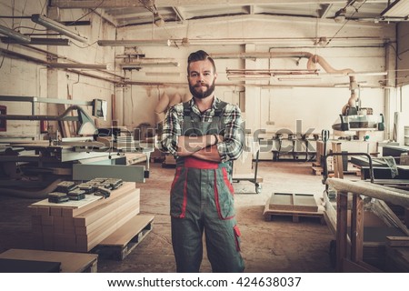 Carpenter doing his job in carpentry workshop.
