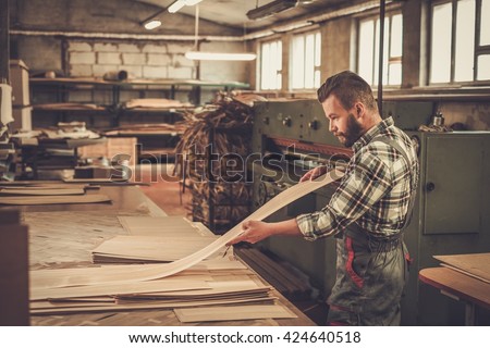 Carpenter doing his job in carpentry workshop.