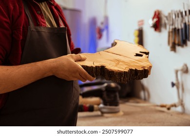 Carpenter doing last touches on piece of wood before using it for furniture assembly, close up shot. Man with injured finger doing woodworking process on lumber block, inspecting for damages - Powered by Shutterstock