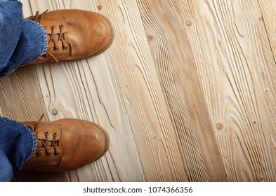 Carpenter Feet In Work Boots Standing On Wooden Floor. Place For Text