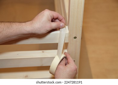 Carpenter glue masking tape on wooden furniture. Home carpentry - Shutterstock ID 2247281191