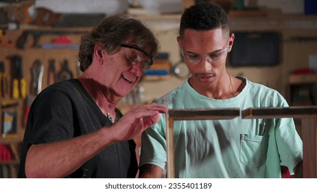 Carpenter Guiding Apprentice at Carpentry Workshop, Teaching Woodwork Using Saw Machine to Slice Piece of Wood, Industry Job - Powered by Shutterstock