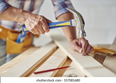 Carpenter with hammer hitting nails